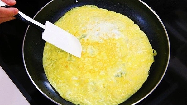 Cho cơm vào giữa và cuộn trứng lại